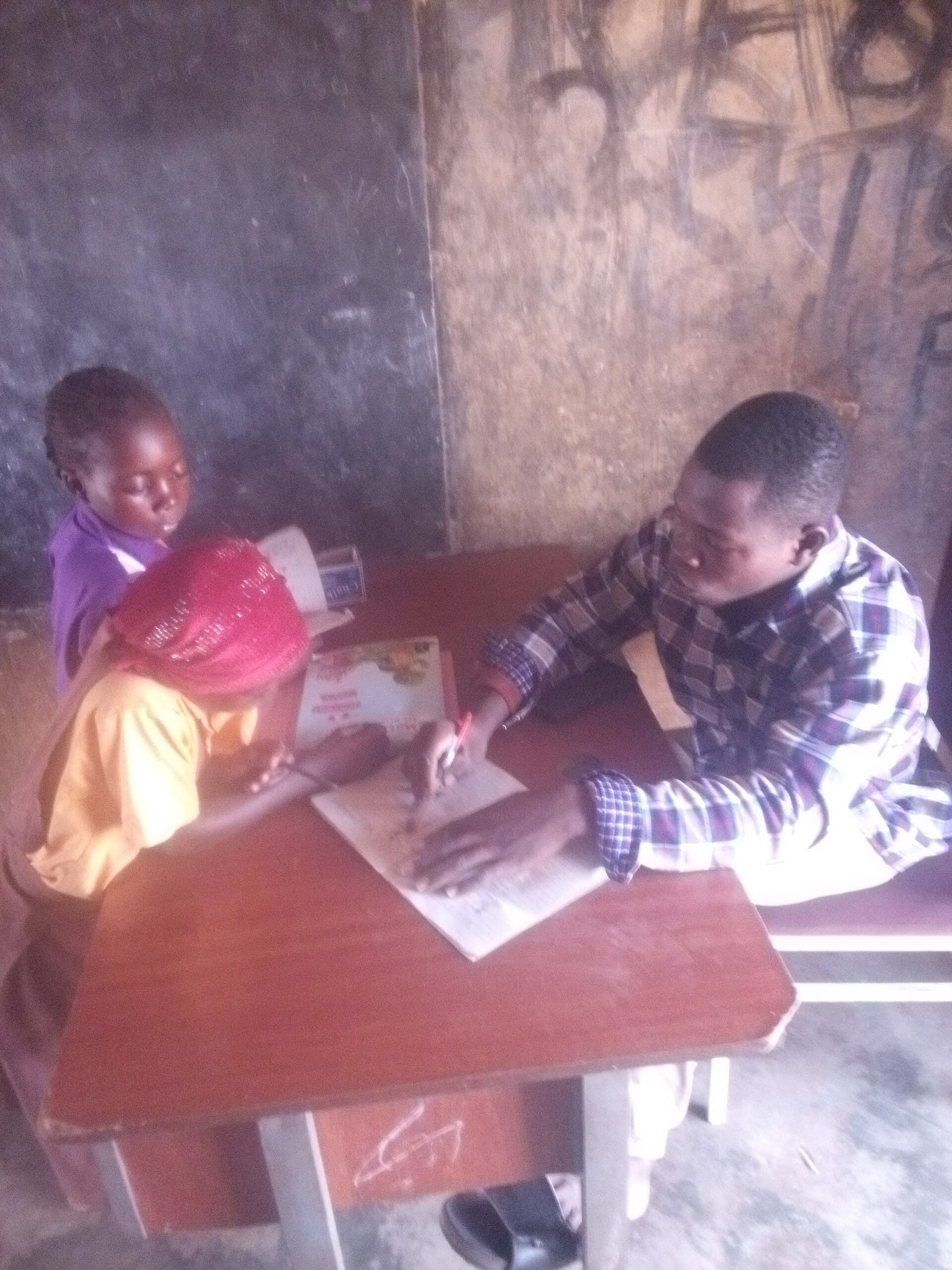 A teacher helping a young student learn to write